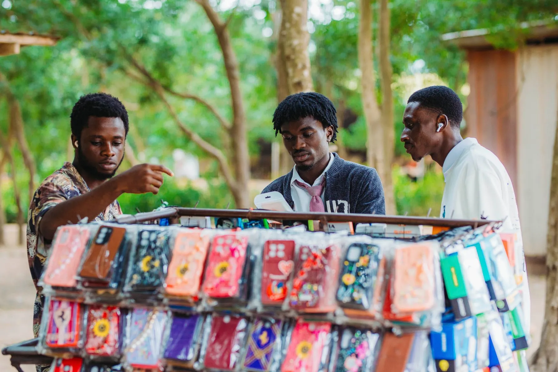 Young traders selling phone cases from a mobile street display